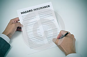 A young man signing a hazard insurance policy