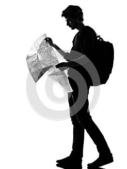 Young man silhouette backpacker reading map