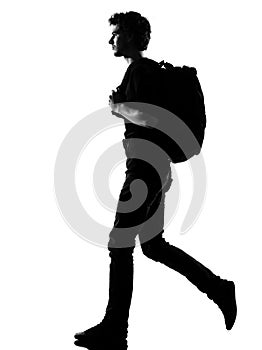 Young man silhouette backpacker walking photo