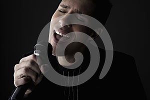 Young man singing into microphone close-up