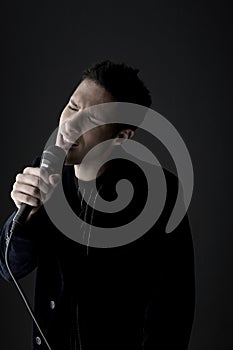 Young man singing into microphone close-up