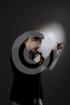 Young man singing into microphone close-up