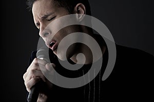 Young man singing into microphone close-up