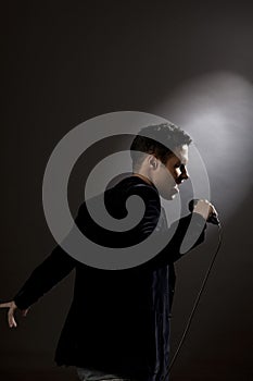 Young man singing into microphone close-up