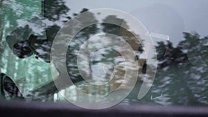 The young man sit in the car and talking on the phone.