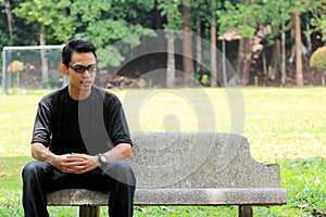 Young man sit on the stone bench