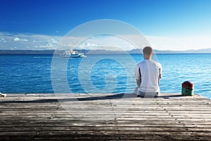 Young man siting on pier