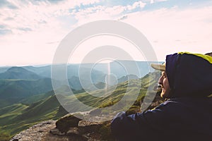 Young Man sitting alone outdoor green valley sunset mountains on background Travel Lifestyle and survival concept