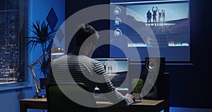 Young man sitting back and editing video inside a room photo