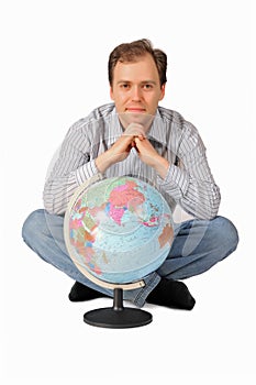 Young man sitting in behind the globe