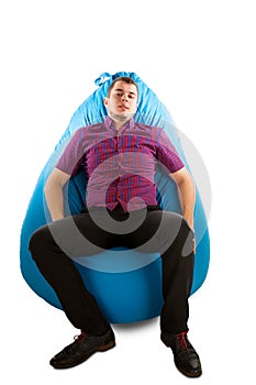 Young man sitting on blue beanbag