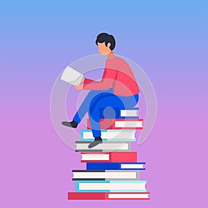 Young man sitting on books reading book, pile of books