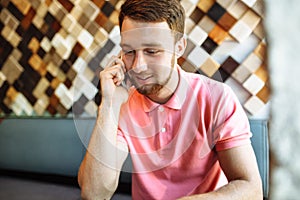 Young man sitting in cafe with laptop and phone, working, shopping online, hipster