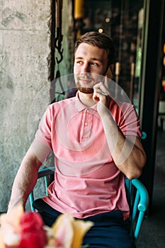 Young man sitting in cafe with laptop and phone, working, shopping online, hipster