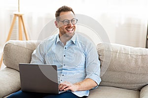 Young man sitting on couch and looking aside