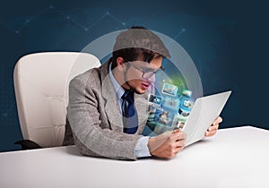 Young man sitting at desk and watching his photo gallery on laptop