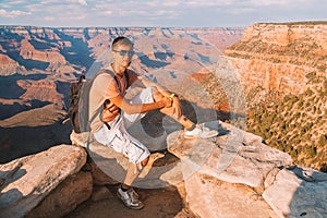 Young man sitting at the edge of the Grand Canyon