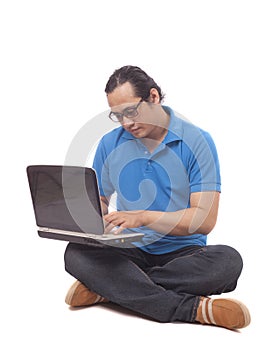 Young Man Sitting on Floor and Typing on Laptop