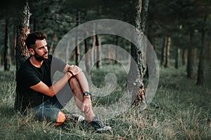 Young man sitting on grass contemplating