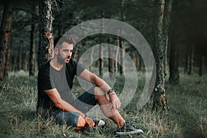 Young man sitting on grass contemplating