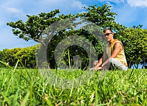 Young man sitting on the grass and working with laptop