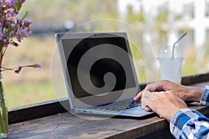 A young man sitting at his desk with his laptop typing keyboard enjoys surfing the internet and looking for ideas for working in a