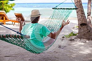 Young man sitting in the lotus position at hammock