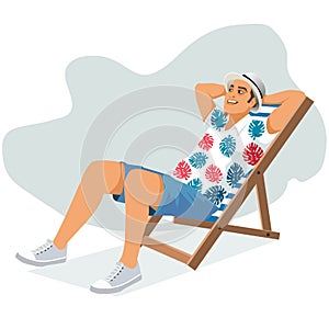 Young man sitting in lounge deck chair at the beach and relaxing