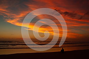 Young man sitting outdoors watching the sunset. Thinking and relaxing concept, Australia