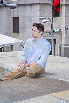 Young man sitting outside, relaxing, thinking
