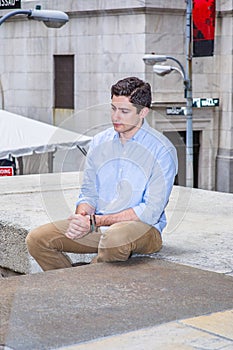 Young man sitting outside, relaxing, thinking
