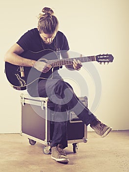 Young man sitting and playing guitar