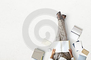 Young man sitting and reading a book on the floor
