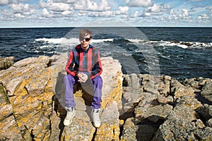 Young man sitting on rocks