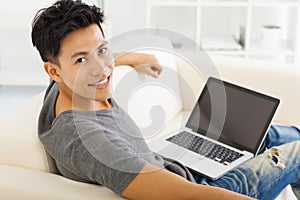 Young Man sitting in sofa and using laptop