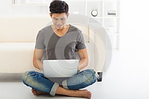 young Man sitting in sofa and using laptop