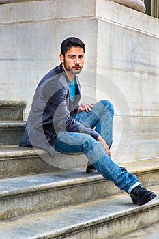 Young Man sitting on stairs outdoors, relaxing, thinking
