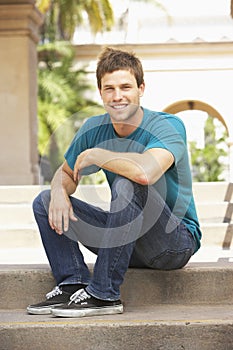 Young Man Sitting On Steps Of Building