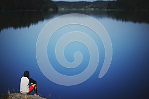 Young man sitting on the stone enjoying peaceful moment