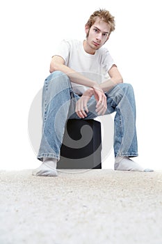 Young man sitting on a subwoofer