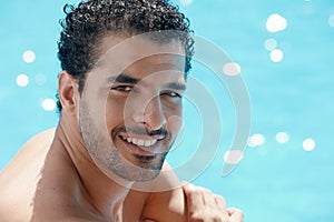 Young man sitting in swimming pool