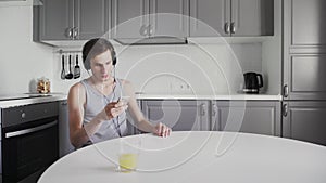 Young Man sitting at the table And Listening Music In Headphones