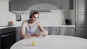 Young Man sitting at the table And Listening Music In Headphones