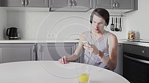 Young Man sitting at the table And Listening Music In Headphones