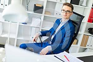 A young man is sitting at a table in the office.