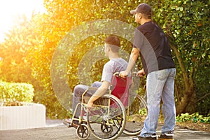 Young man sitting on a wheelchair with his brother