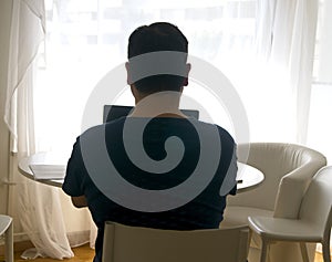 Young man sitting and working on laptop at home. Working father concept. teleworking concept