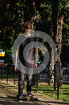 Young man on skateboard riding in city park - sport, youth, lifestyle concept