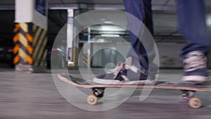 A young man skateboarding on his board with military colors on a high speed in the parking lot. Side view