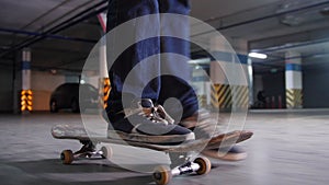 A young man skateboarding on his board with military colors in the parking lot. Feet in focus.